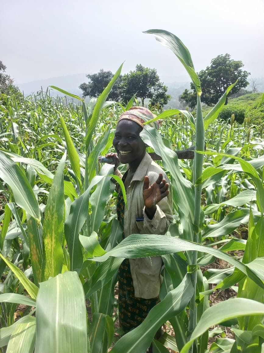 A farmer smiling in her maize field