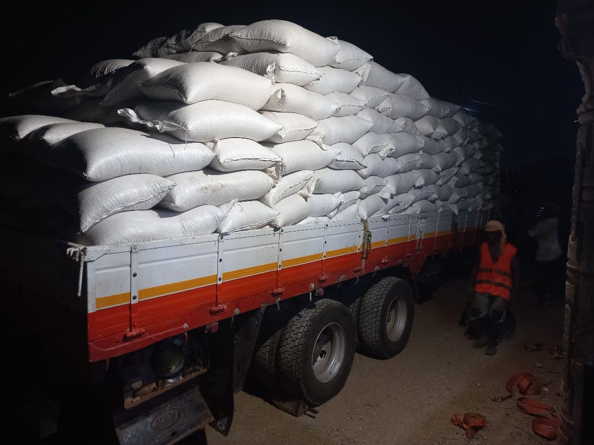 A grain truck loaded and strapped down for a night dispatch
