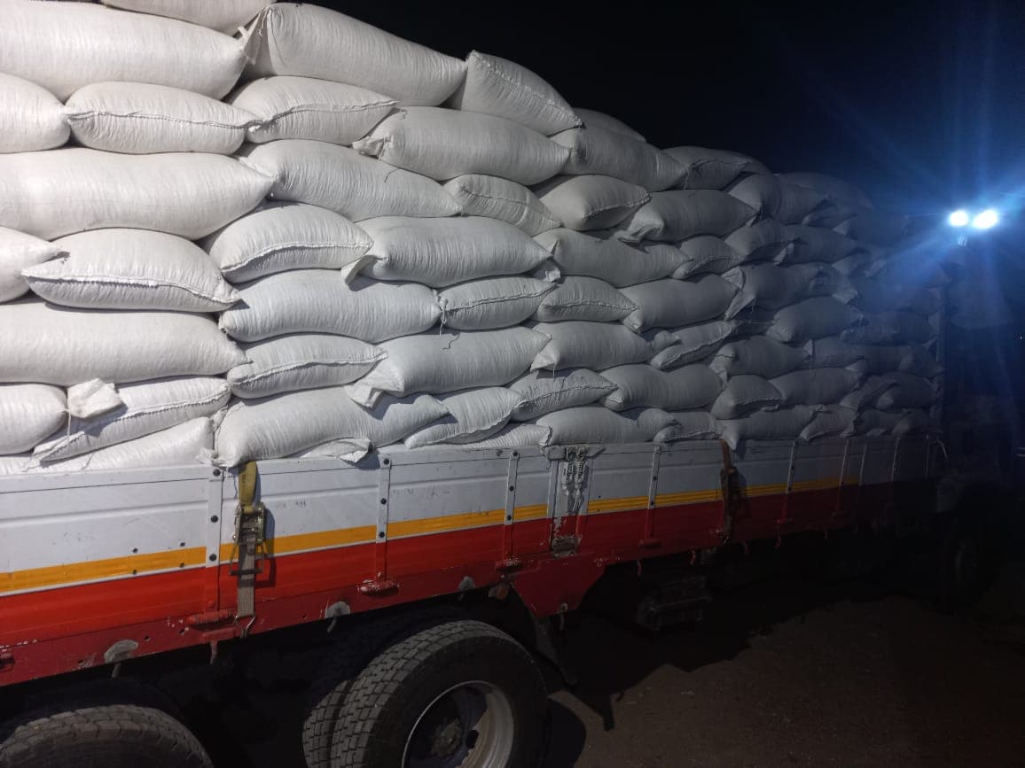 Bagged grain stacked high on a departing truck